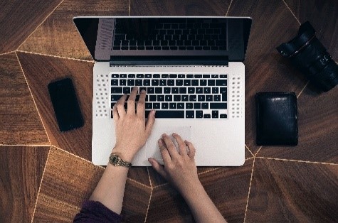 Someone's hands are shown from above using a laptop.
