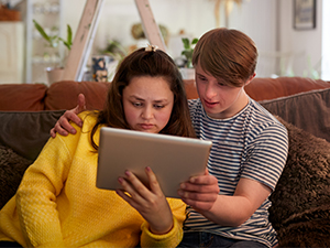 Two people reading a tablet together