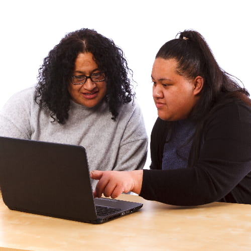 two women looking at a laptop