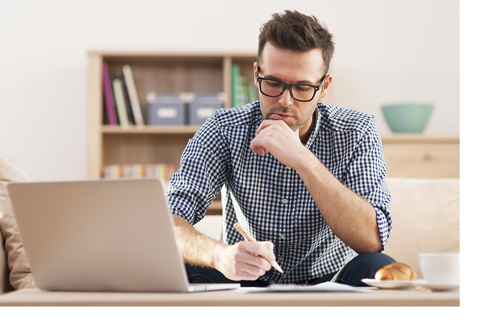 man writing at his computer