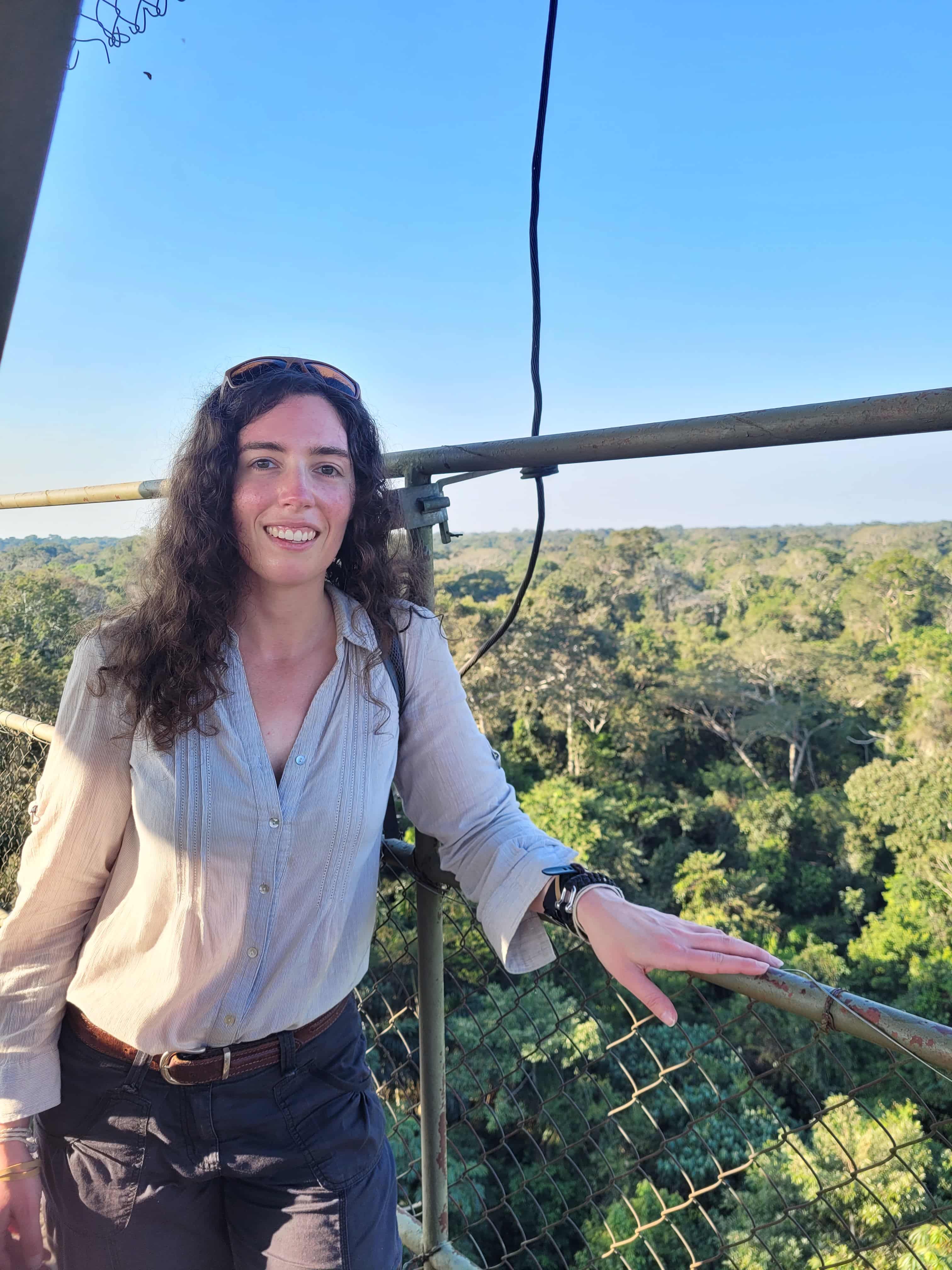 Catie standing on a platform above a forest.