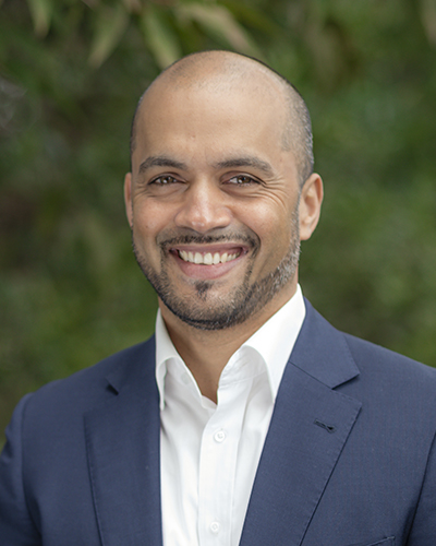 A head and shoulders photo of Sean de Kretser. He is wearing a white shirt and blue suit jacket.