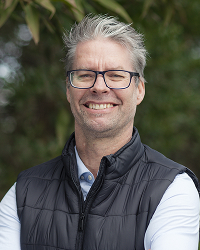 A head and shoulders photo of Kellie. He is wearing glasses.